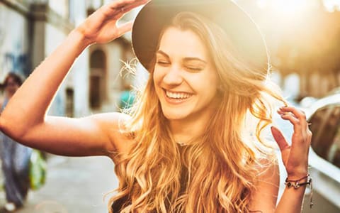 Portrait of young woman with hat smiling